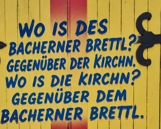 Gelbes Eingangstor des Bacherner Brettls gegenüber der Kirche